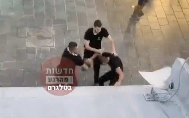 لقطة شاشة من مقطع فيديو يظهر هجوم مجموعة يهود على رجل عربي في سوق محانيه يهودا في القدس، 22 أغسطس 2022 (Screen capture: Twitter)