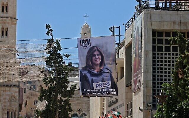 لافتات تحمل صورة الصحفية الفلسطينية الأمريكية شيرين أبو عاقله معلقة على مبنى يطل على كنيسة المهد في بيت لحم في الضفة الغربية، 14 يوليو 2022 (Ahmad Gharabli / AFP)
