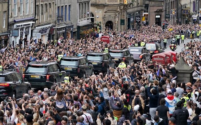 حشود تشاهد الموكب الذي ينقل نعش الملكة إليزابيث الثانية، أثناء مروره عبر إدنبرة باتجاه قصر هوليرودهاوس في اسكتلندا، 11 سبتمبر 2022 (Ian Forsyth / POOL / AFP)