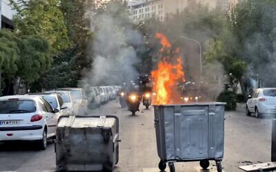 صورة حصلت عليها وكالة فرانس برس خارج إيران تظهر حاويات نفايات تحترق في وسط تقاطع أثناء احتجاج على مقتل مهسا أميني، 20 سبتمبر 2022 (AFP)