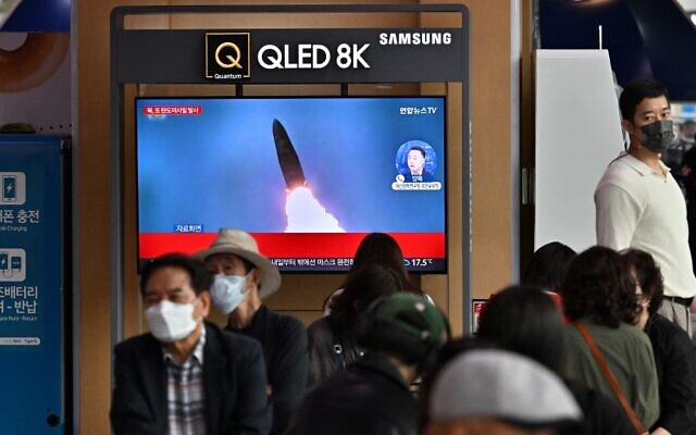 أشخاص يشاهدون شاشة تلفزيونية تظهر بثا إخباريا مع لقطات من الأرشيف لتجربة صاروخ كوري شمالي، في محطة للسكك الحديدية في سيول في 25 سبتمبر 2022.  (Jung Yeon-je / AFP)