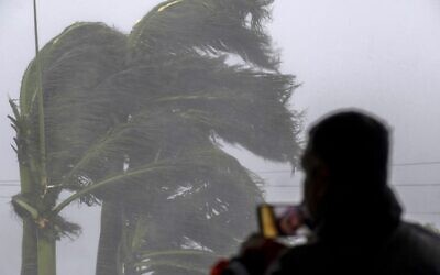 رجل ينقل في بث مباشر هبوب إعصار إيان في بونتا غوردا، فلوريدا 28 سبتمبر، 2022. (Ricardo ARDUENGO / AFP)