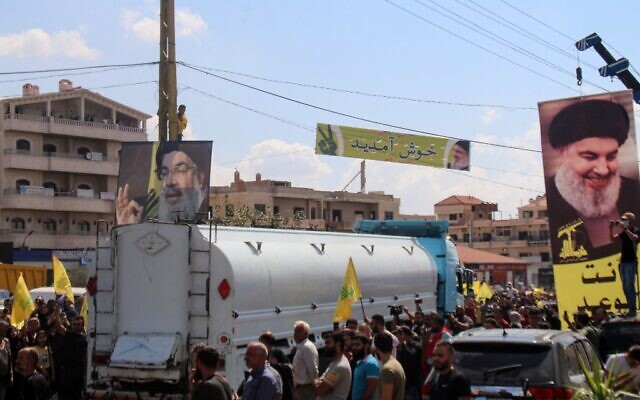 ملف: اشخاص يحملون صور زعيم حزب الله، حسن نصر الله، للترحيب بناقلات تحمل وقودًا إيرانيًا عند وصولها من سوريا إلى مدينة بعلبك في سهل البقاع اللبناني، 16 سبتمبر 2021 (AFP)