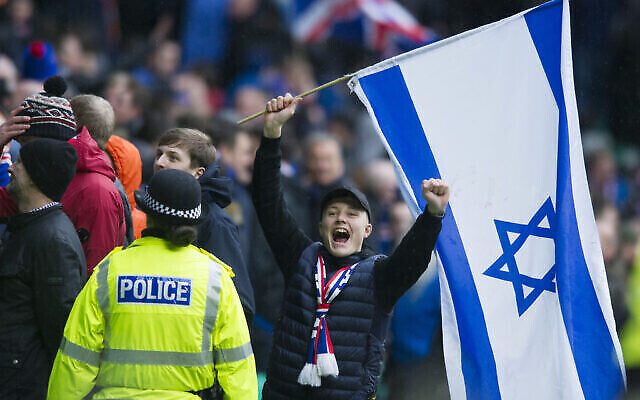 أحد مشجعي نادي الرينجرز يحتفل برفع العلم الإسرائيلي خلال مباراة ضد سلتيك في عام 2017. (Ross MacDonald / SNS Group via Getty Images / via JTA)