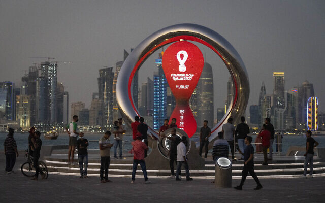 أشخاص متجمعون حول ساعة العد التنازلي الرسمية التي تظهر الوقت المتبقي حتى انطلاق مونديال 2022، في الدوحة، قطر، 25 نوفمبر 2021 (AP / Darko Bandic)
