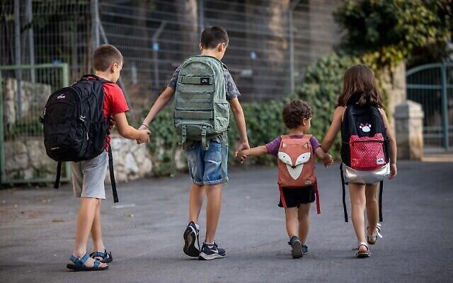 أطفال إسرائيليون يحملون الحقائب مدرسية في اليوم الأول من العام الدراسي خارج منزلهم في القدس في 31 أغسطس 202 ، يفتح جهاز التعليم  العلماني الإسرائيلي العام االدراسي في 1 سبتمبر. (Yonatan Sindel / Flash90)