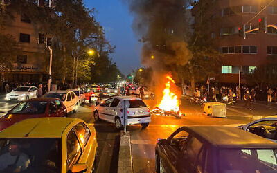 دراجة نارية للشرطة تحترق خلال مظاهرة في وسط طهران ، إيران ، 19 سبتمبر، 2022. (AP Photo ، File)