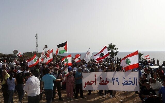 متظاهرون لبنانيون يشاركون في مظاهرة في بلدة الناقورة الحدودية، بعد أيام من نقل إسرائيل لسفينة لإنتاج الغاز إلى حقل "كاريش" البحري، الذي يطالب لبنان بجزء منه، 11 يونيو  2022 (Mahmoud Zayyat/ AFP)