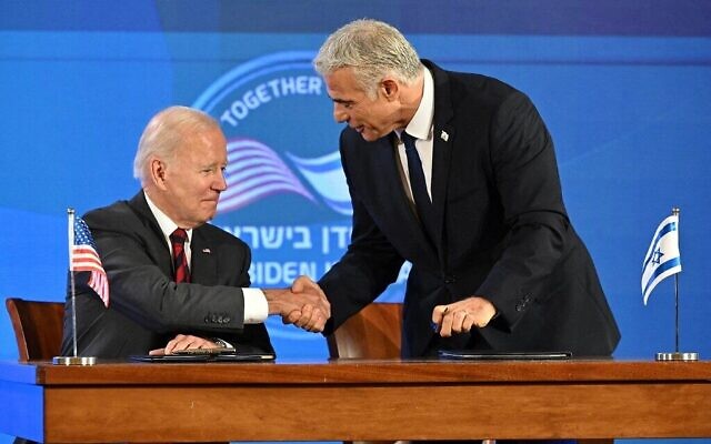 الرئيس الأمريكي جو بايدن (يسار) ورئيس الوزراء الإسرائيلي يائير لبيد يتصافحان بعد التوقيع على إعلان القدس قبل بدء مؤتمر صحفي مشترك في القدس، 14 يوليو 2022 (Mandel Ngan / AFP)