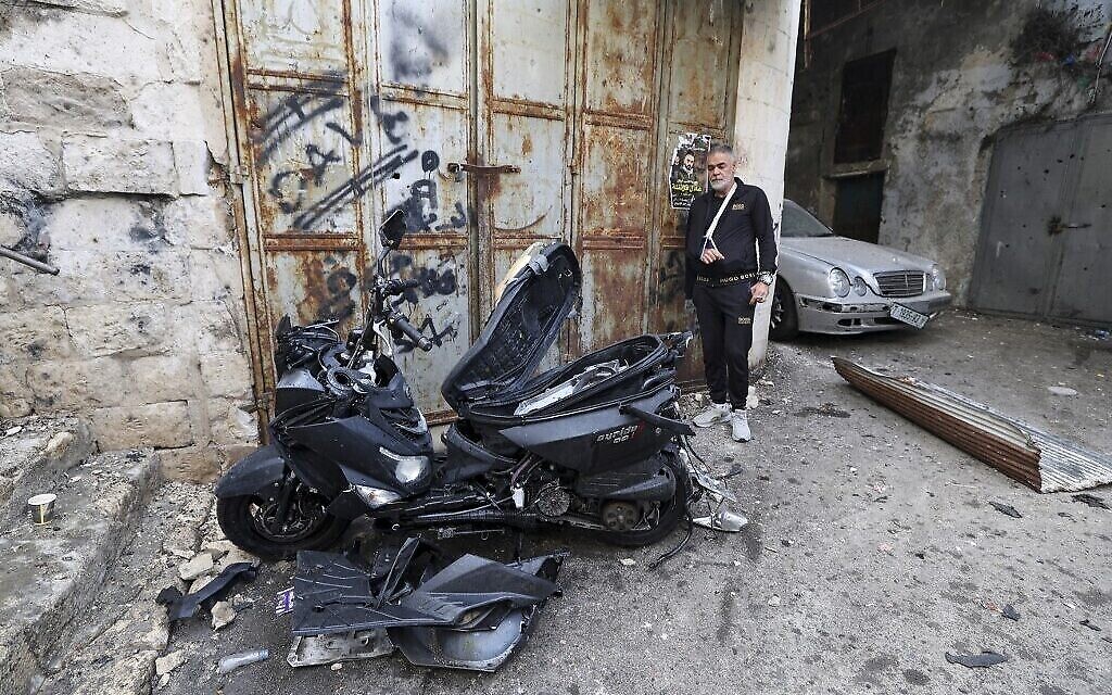 فلسطينيون يحتشدون حول دراجة نارية استخدمت لقتل تامر الكيلاني في مدينة نابلس القديمة، 23 أكتوبر، 2022. (JAAFAR ASHTIYEH / AFP)