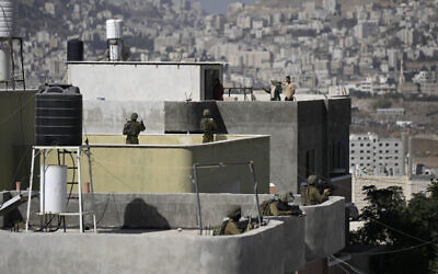 قوات الأمن الإسرائيلية تنتشر على سطح منزل فلسطيني خلال عملية تفتيش في سالم بالقرب من مدينة نابلس بالضفة الغربية، في أعقاب هجوم إطلاق نار تبناه فصيل "عرين الأسود"، 2 أكتوبر، 2022. (AP / Majdi Mohammed)