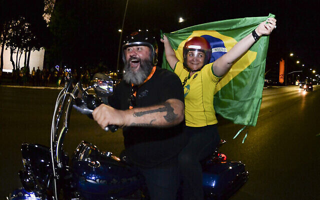 أنصار الرئيس البرازيلي جاير بولسونارو يركبون دراجة نارية بعد إغلاق صناديق الاقتراع في الانتخابات العامة في برازيليا، البرازيل،  2 أكتوبر، 2022. (AP / Ton Molina)