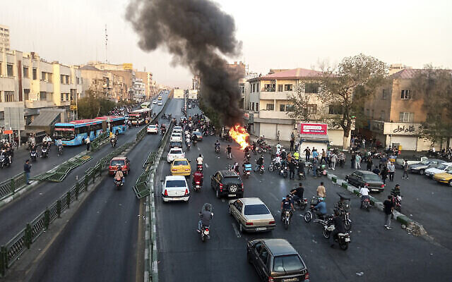 إضرام النار في دراجة نارية تابعة لميليشيا الباسيج الإيرانية الشبه عسكرية خلال مظاهرة بعد  الشابة مهسا أميني (22 عاما) عندما احتجزتها شرطة الأخلاق في طهران، 10 أكتوبر، 2022.(AP Photo/Middle East Images)