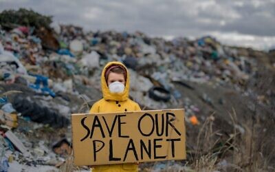 طفل يقف في موقع لطمر نفايات ويدعو لإنقاذ كوكبنا. (هاف بوينت، 12 يونيو 2020، iStock bs Getty Images)