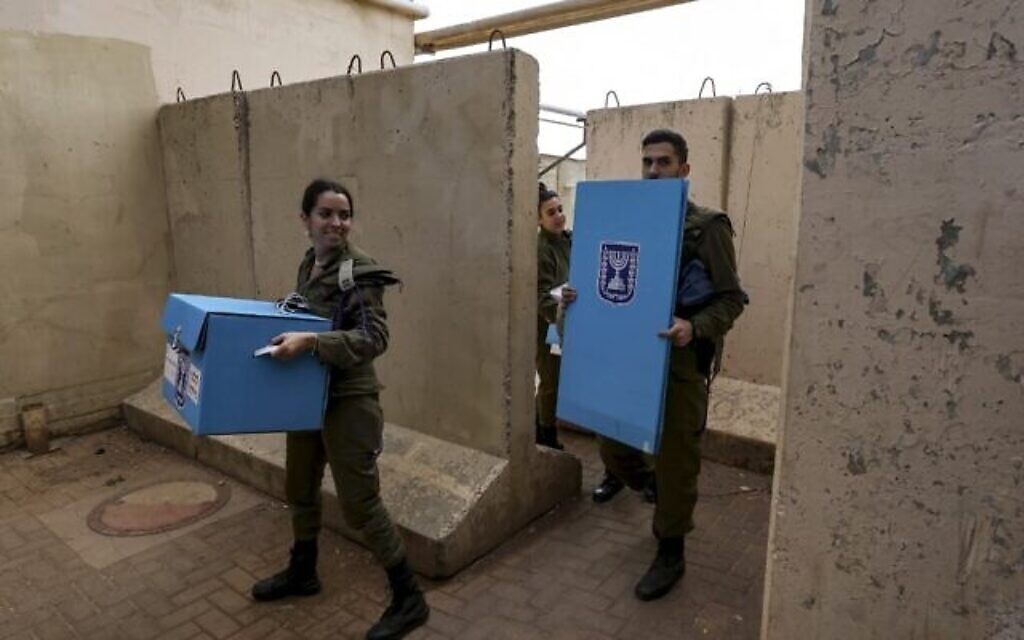 جنود إسرائيليون يصلون بمعدات انتخابية لتسهيل التصويت المبكر للجنود في الانتخابات العامة الإسرائيلية، في قاعدة هار دوف العسكرية في جبل الشيخ في الجولان، 31 أكتوبر، 2022. (Photo by JALAA MAREY / AFP)