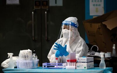 عاملة صحية ترتدي قفازات أثناء إجراء اختبارات كوفيد-19 لجميع السكان في ماكاو، الصين، 1 نوفمبر 2022 (Eduardo Leal / AFP)