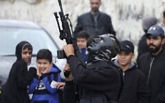 مسلح ملثم يطلق النار في الهواء خلال تشييع جثمان فلسطينيين قتلوا خلال اشتباكات مع الجيش الإسرائيلي في قرية بيت ريما في الضفة الغربية، 29 نوفمبر 2022 (Jaafar Ashtiyeh / AFP)