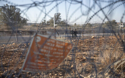 جنود من الجيش الإسرائيلي يحرسون قسما من السياج الفاصل الإسرائيلي، في قرية نعلين بالضفة الغربية، غرب رام الله، 7 نوفمبر، 2021. (AP Photo / Nasser Nasser، File)