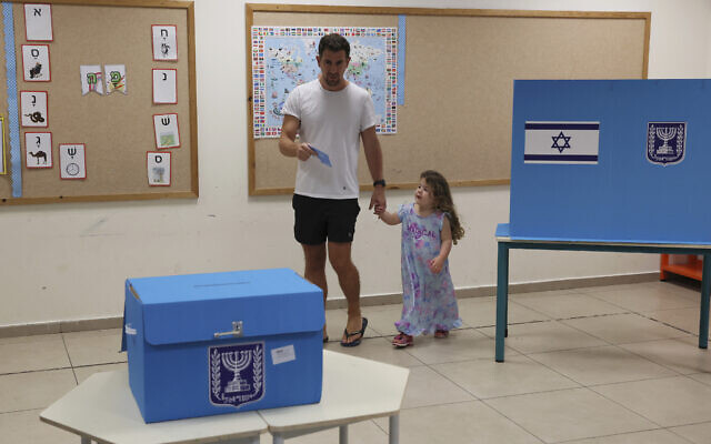 رجل يسير مع فتاة صغيرة نحو صندوق الاقتراع للإدلاء بصوته في تل أبيب، 1 نوفمبر 2022 (Jack Guez / Pool Photo via AP)