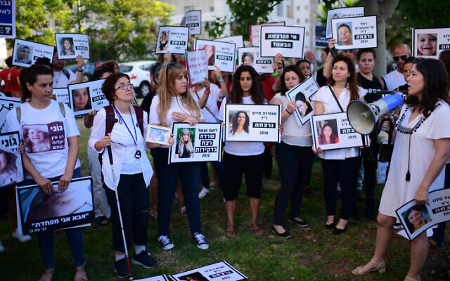 متظاهرات يحملن لافتات عليها صور لنساء قُتلن، أثناء احتجاج ضد العنف ضد النساء، في تل أبيب، 25 يونيو 2022 (Tomer Neuberg / FLASH90)