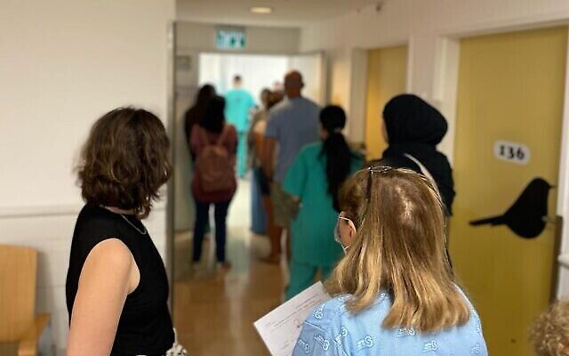 مرضى وطاقم مستشفى ينتظرون في طابور للتصويت في مركز اقتراع في مركز شيبا الطبي، 1 نوفمبر 2022 (كاري كيلر لين / تايمز أوف إسرائيل)