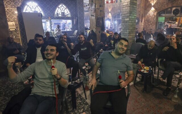 عرب اسرائيليون يحتفلون بالهدف الافتتاحي للمغرب وهم يشاهدون مباراة ربع نهائي كأس العالم قطر 2022 بين المغرب والبرتغال، في مقهى في يافا، 10 ديسمبر 2022 (AHMAD GHARABLI / AFP)