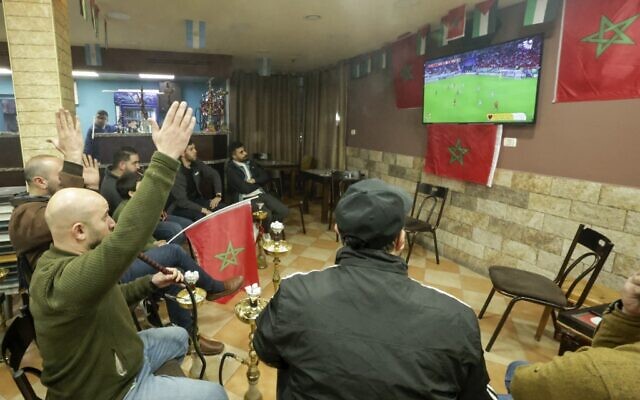 فلسطينيون يحتفلون بفوز المغرب على البرتغال في شوارع مدينة الخليل بالضفة الغربية بعد مباراة ربع نهائي كأس العالم في قطر، 10 ديسمبر 2022 (HAZEM BADER / AFP)