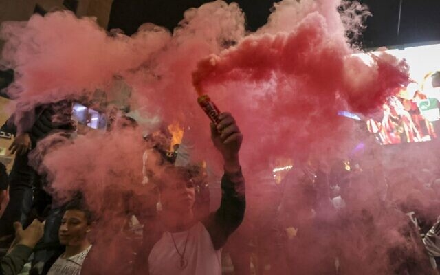 فلسطينيون يحتفلون بفوز المغرب على البرتغال في شوارع مدينة الخليل بالضفة الغربية بعد مباراة ربع نهائي كأس العالم في قطر، 10 ديسمبر 2022 (HAZEM BADER / AFP)