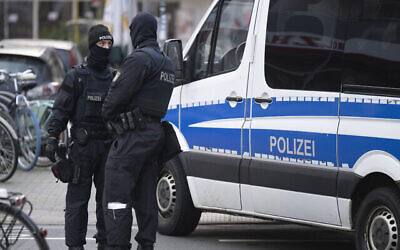 شرطيان ألمانيان يقفان بجانب عقار تم تفتيشه في فرانكفورت خلال مداهمة ضد من يسمون "مواطنو الرايخ" في فرانكفورت، ألمانيا، الأربعاء، 7 ديسمبر.  2022. (Boris Roessler/dpa via AP)