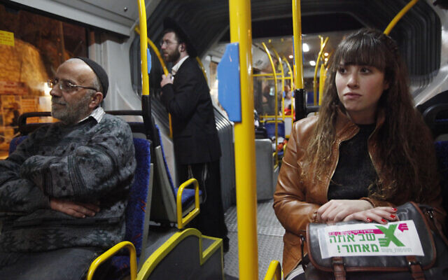توضيحية: إسرائيليون علمانيون يستقلون حافلة تفصل بين الجنسين، حيث تجلس النساء في الجزء الخلفي من الحافلة والرجال في المقدمة. جلست امرأة علمانة بين الرجال اليهود المتدينين في المقدمة، كجزء من احتجاج ضد استبعاد النساء في المجال العام، 1 يناير 2012 (Miriam Alster / Flash90)