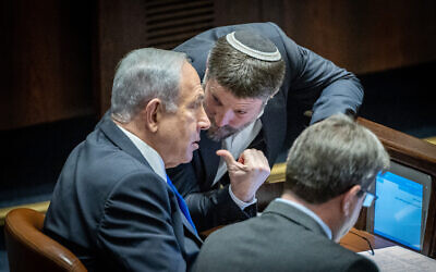 زعيم الليكود، عضو الكنيست بنيامين نتنياهو (يسار) يتحدث مع رئيس حزب "الصهيونية الدينية"، بتسلئيل سموتريتش، خلال تصويت في الكنيست، 20 ديسمبر 2022 (Yonatan Sindel / Flash90)
