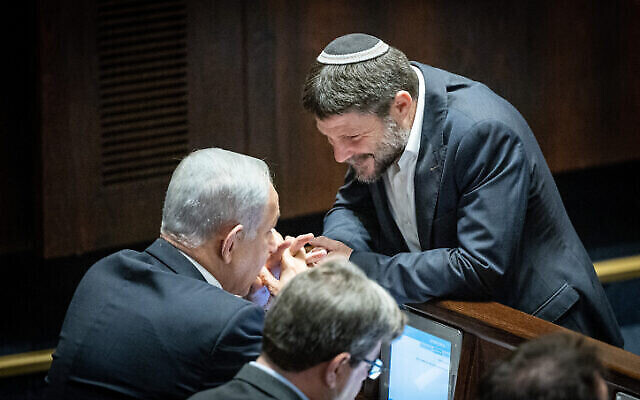 رئيس حزب "الصهيونية الدينية"، عضو الكنيست بتسلئيل سموتريتش (على يمين الصورة)، يتحدث مع زعيم الليكود، بنيامين نتنياهو، خلال تصويت في الكنيست، 20 ديسمبر، 2022. (Yonatan Sindel / Flash90)