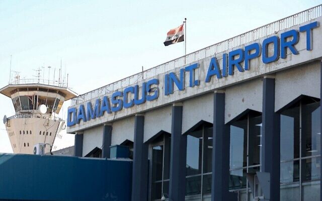العلم السوري يرفرف في مطار دمشق الدولي خارج العاصمة السورية، 1 أكتوبر 2020 (Louai Beshara/AFP)