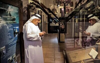 أحمد المنصوري، مدير متحف "معبر الحضارات"، يرشد الزائرين حول معرض المحرقة في المتحف في دبي، 11 يناير 2023. (Karim SAHIB / AFP)