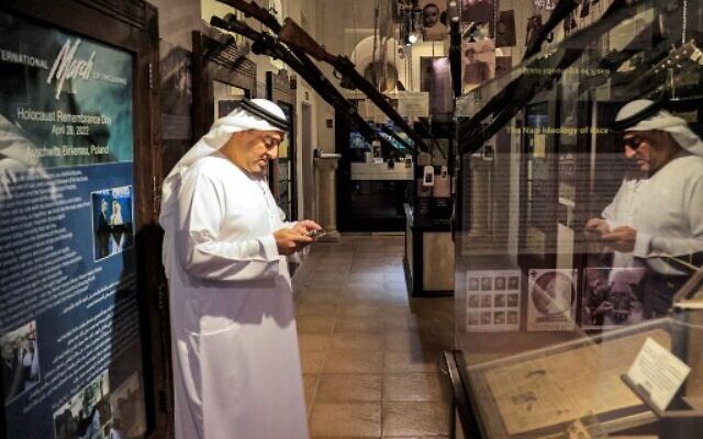 أحمد المنصوري، مدير متحف "معبر الحضارات"، يرشد الزائرين حول معرض المحرقة في المتحف في دبي، 11 يناير 2023. (Karim SAHIB / AFP)