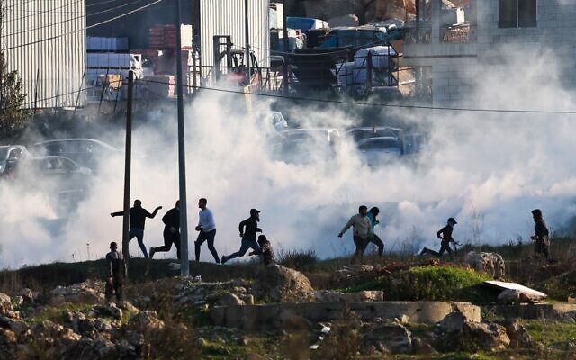 القوات الإسرائيلية تطلق الغاز المسيل للدموع لتفريق متظاهرين فلسطينيين خلال مواجهات بالقرب من رام الله، 26 يناير 2023 (Ahmad Gharabli / AFP)