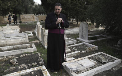 حسام نعوم، أسقف أنجليكاني فلسطيني، يقف حيث قام مخربون بتدنيس أكثر من 30 قبرًا في مقبرة بروتستانتية تاريخية في جبل صهيون في القدس، 4 يناير 2023 (AP Photo / Mahmoud Illean)