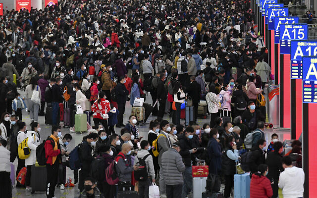 أشخاص يرتدون أقنعة الوجه يستعدون مع أمتعتهم للحاق بقطاراتهم في محطة القطار الشمالية في شنجن، بمقاطعة قوانغدونغ جنوب الصين، 7 يناير 2023 (Liang Xu/Xinhua via AP)