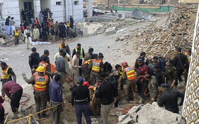 مسؤولو الأمن وعمال الإنقاذ ينتشلون الجثث في موقع التفجير الانتحاري في بيشاور، باكستان، 30 يناير 2023 (AP / Zubair Khan)