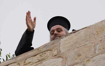 البطريرك اليوناني السابق إيرينيوس الأول يلوح من سطح شقته في البلدة القديمة في القدس، 6 ينايرـ 2011. (AP / Dan Balilty)