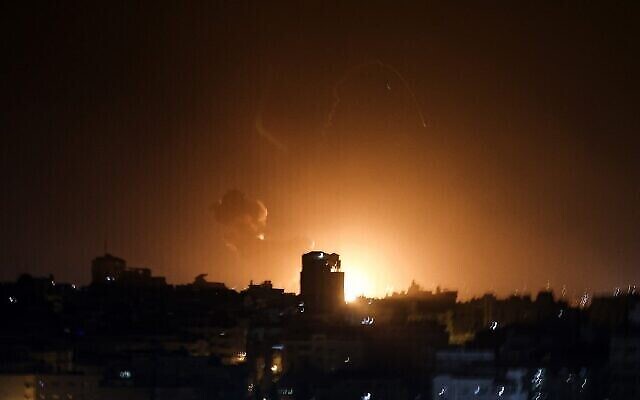 النار والدخان يتصاعدان فوق مباني في مدينة غزة خلال غارات جوية إسرائيلية على القطاع الفلسطيني فجر 2 فبراير، 2023. (MOHAMMED ABED / AFP)
