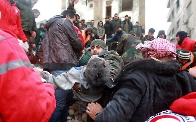 فرق الانقاذ السورية تنقل جثة انتشلت من تحت الانقاض بعد زلزال في مدينة حماة التي يسيطر عليها النظام وسط سوريا، 6 فبراير، 2023. (LOUAI BESHARA / AFP)