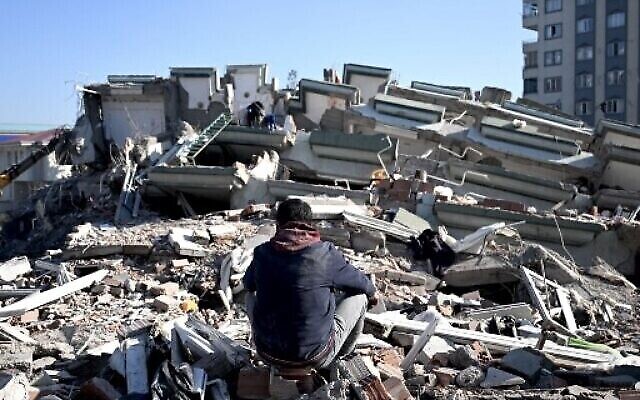 رجل يجلس بين أنقاض المباني المنهارة في كهرمانماراس ، في 9 فبراير 2023 ، بعد ثلاثة أيام من وقوع زلزال بقوة 7.8 درجة في جنوب شرق تركيا. (OZAN KOSE / AFP)