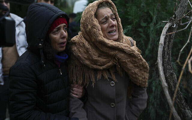 سيدتان تبكيان بينما تشاهدان فرق الطوارئ تبحث عن أشخاص تحت أنقاض مبنى مدمر في أضنة، تركيا  6 فبراير، 2023. (AP Photo / Khalil Hamra)