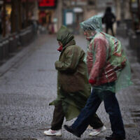 اشخاص يسيرون تحت المطر وسط مدينة القدس، 1 فبراير، 2023. (Yonatan Sindel / Flash90)
