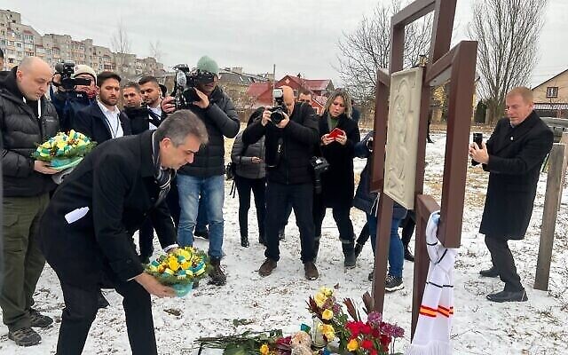 وزير الخارجية إيلي كوهين يضع إكليلا من الزهور على مقبرة جماعية تضم 116 مدنيا قتلوا على يد الروس في بوتشا، كييف، أوكرانيا، 16 فبراير، 2023. (Lazar Berman / Times of Israel)