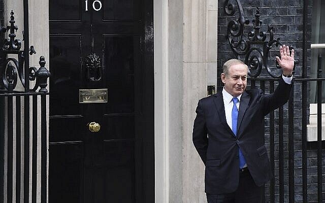 رئيس الوزراء بنيامين نتنياهو يلوح بيده لوسائل الإعلام بعد وصوله إلى 10 داونينغ ستريت في لندن للقاء مع نظيرته البريطانية آنذاك تيريزا ماي، 6 فبراير، 2017. (AFP Photo / Chris J Ratcliffe)
