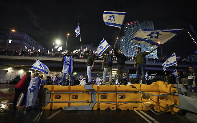 متظاهرون يغلقون طريقا سريعا خلال احتجاج على خطط حكومة رئيس الوزراء بنيامين نتنياهو لإصلاح النظام القضائي في تل أبيب، 25 مارس، 2023. (AP Photo / Ariel Schalit)