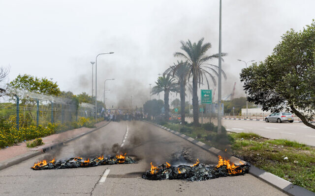 إطارات مشتعلة عند مدخل ميناء أشدود، خلال احتجاج على الإصلاح القضائي، 23 مارس 2023 (Flash90)