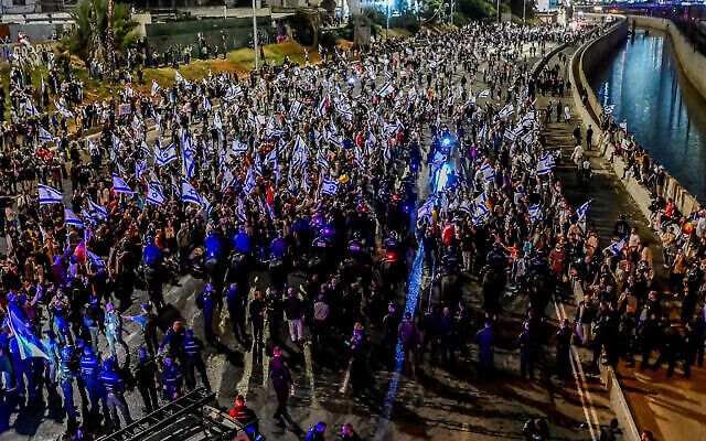 إسرائيليون يغلقون طريق أيالون السريع في تل أبيب خلال احتجاج على الإصلاح القضائي الذي تخطط له الحكومة، 25 مارس، 2023. (Avshalom Sassoni / Flash90)